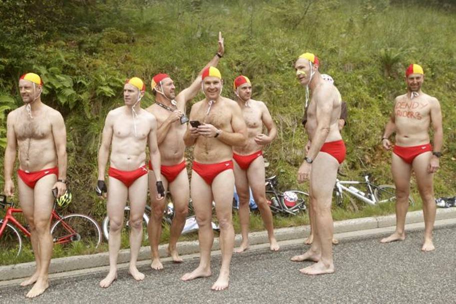 Supporters in costume da bagno attendono l&#39;arrivo del gruppo di ciclisti (Epa)